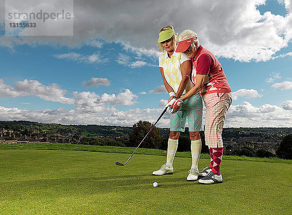 Reife Damen lernen Golf zu spielen