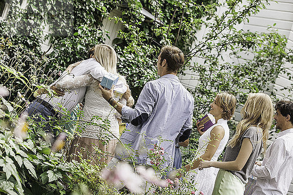 Älteres Paar begrüßt Familie im Garten