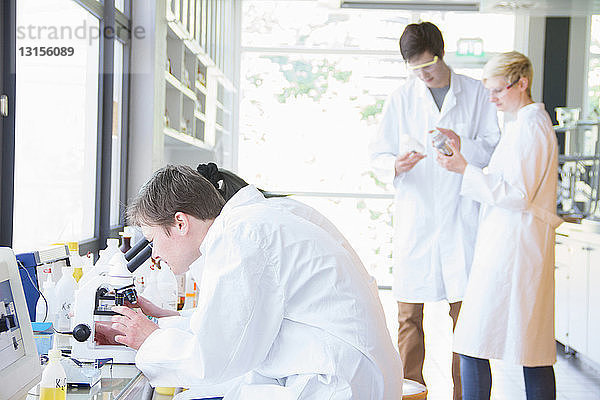 Chemiestudenten verwenden Mikroskope im Labor