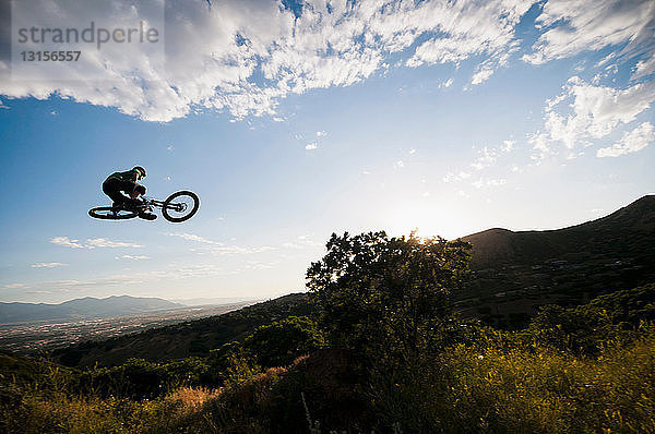 Mountainbiker beim Springen am Hang