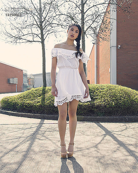 Porträt einer jungen Frau in weißem Kleid  im Freien