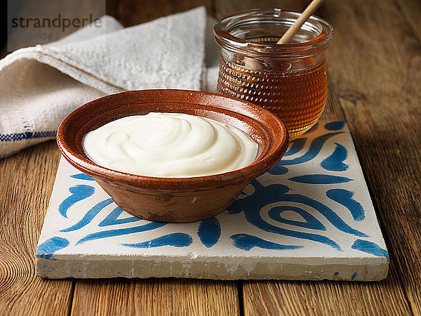 Griechischer Joghurt und Honig auf Kacheln