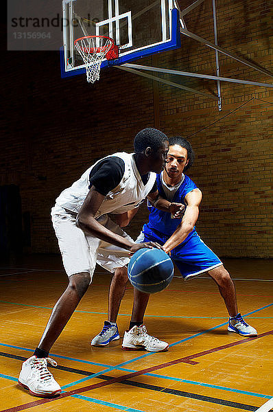 Zwei junge Männer spielen Basketball