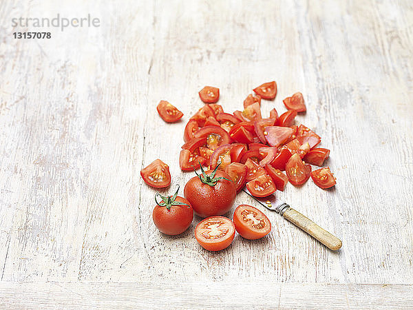 Rote  saftige  süße Tomaten  ganz und in Stücke geschnitten  Messer