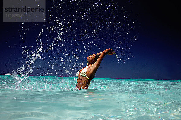 Frau spielt in tropischem Wasser