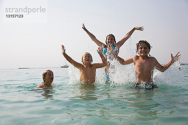 Kinder planschen im Meer