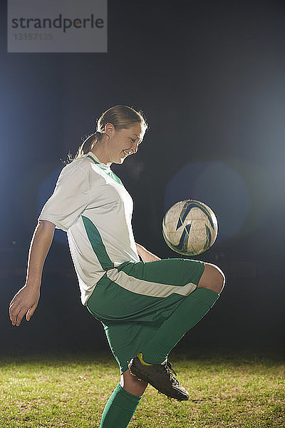Weibliche Fußballspielerin prellt Ball auf Knie