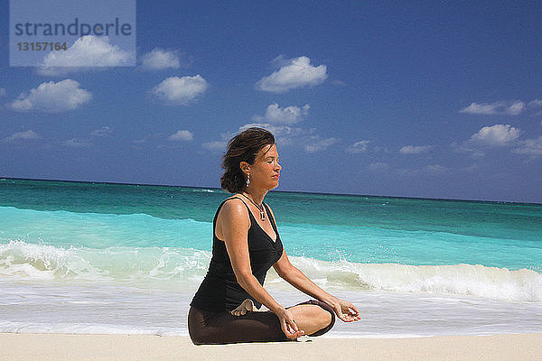 Reife Frau im Lotussitz am Strand  Paradise Island  Nassau  Bahamas