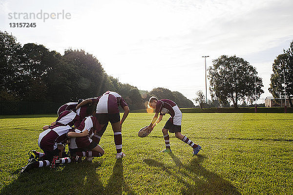 Teenager-Rugbyteam nimmt den Ball aus dem Huddle