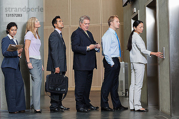 Geschäftsleute warten in der Warteschlange auf den Aufzug