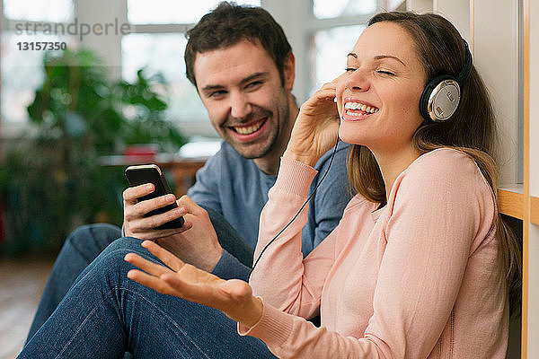 Lachendes junges Paar  Frau trägt Kopfhörer