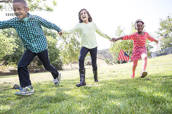 Kinder spielen mit amerikanischer Flagge im Park