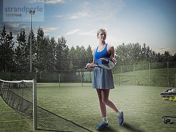 Frau auf Tennisplatz stehend