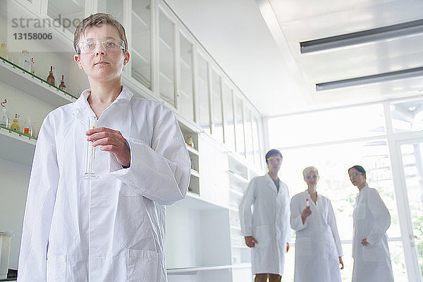 Chemiestudent hält Messzylinder im Labor
