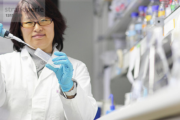 Wissenschaftler pipettiert Flüssigkeit im Labor