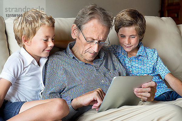 Großvater und Enkel schauen auf ein digitales Tablet