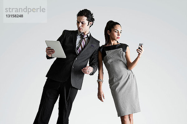 Mann mit digitalem Tablet  Frau mit Mobiltelefon