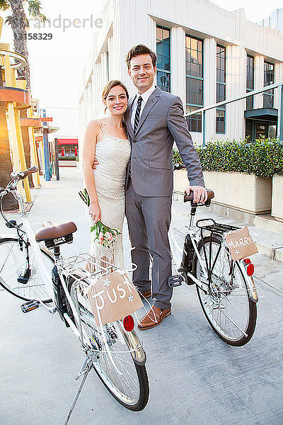 Porträt eines jungen  frisch verheirateten Paares mit Fahrrädern