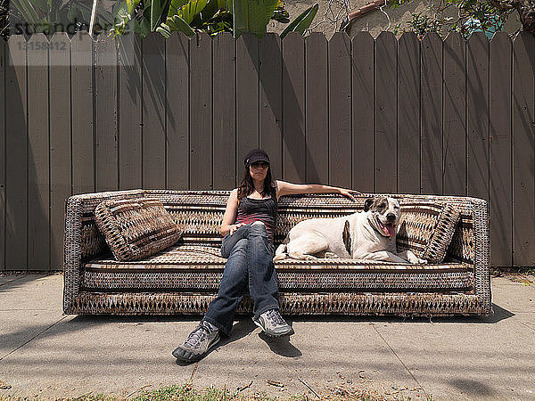 Frau und Hund entspannen sich auf der Couch