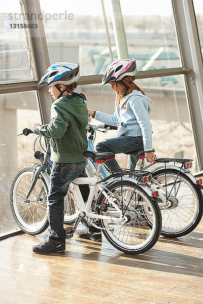 Kinder sitzen auf Fahrrädern auf einer Brücke