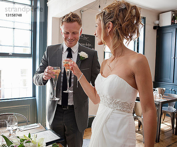 Braut und Bräutigam stoßen bei der Hochzeitszeremonie mit Champagner an