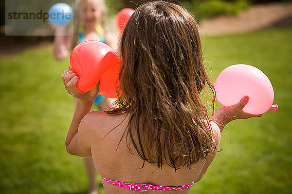 Mädchen spielen mit Wasserballons