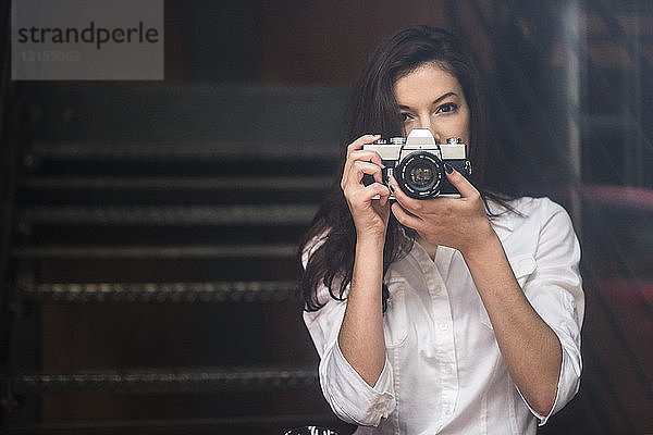 Junge Frau beim Fotografieren mit einer Spiegelreflexkamera