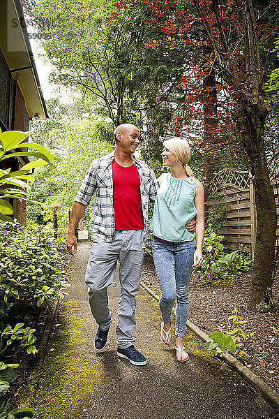 Glückliches Paar spaziert im Garten