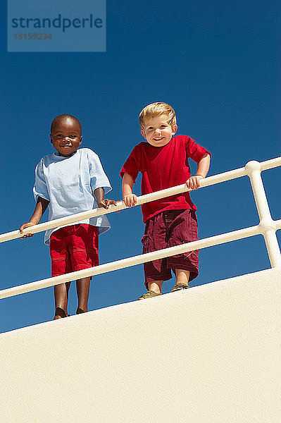 Junge Jungen lehnen sich über das Geländer