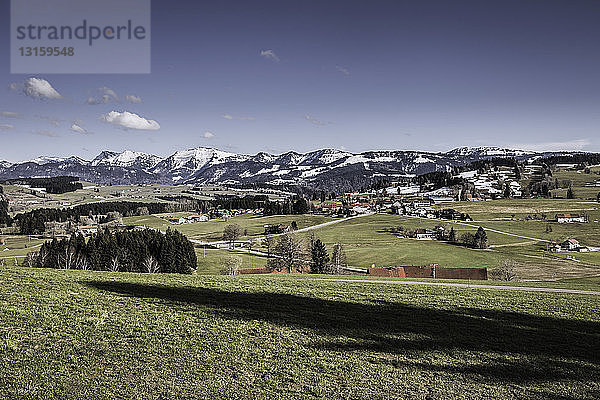 Landschaft mit entfernten schneebedeckten Bergen  Allgäu  Deutschland