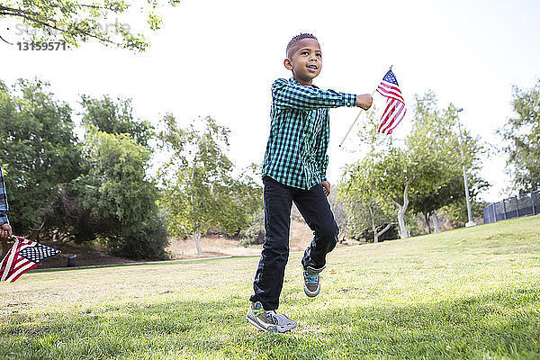 Kinder spielen mit amerikanischer Flagge im Park