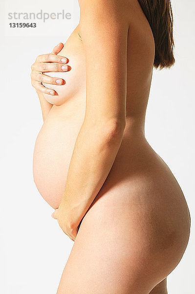 Nackte schwangere Frau  die sich bedeckt
