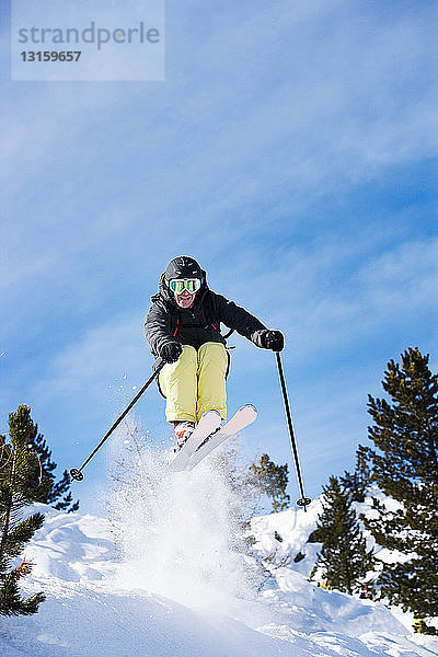 Männlicher Skifahrer in der Luft am Berghang