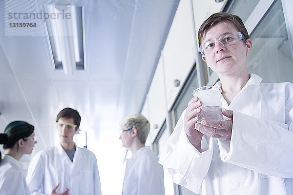 Chemiestudent mit Becherglas im Labor  Porträt