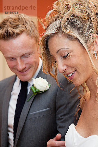 Braut und Bräutigam lächeln bei der Hochzeitszeremonie