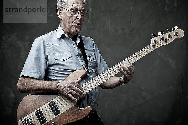 Älterer Mann spielt Bassgitarre