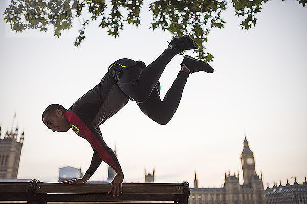 Junger Mann springt über Parkbank am Southbank  London  UK