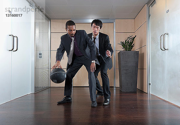 Geschäftsleute spielen Basketball im Büro