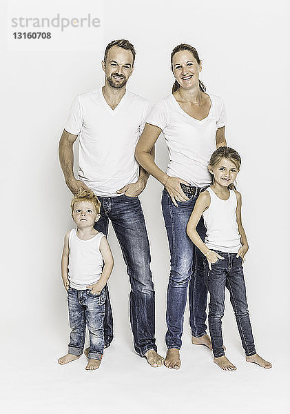 Porträt einer jungen Familie  die zusammen steht und lächelt