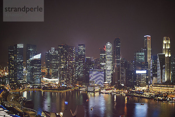 Blick auf Wolkenkratzer am Wasser bei Nacht  Singapur