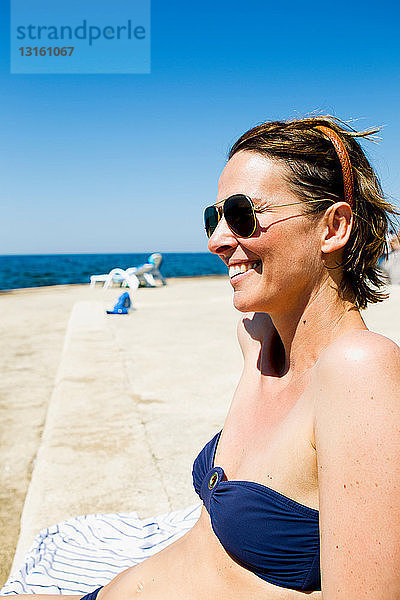 Frau beim Sonnenbaden an der Küste