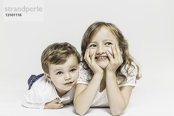 Bruder und Schwester auf dem Bauch liegend