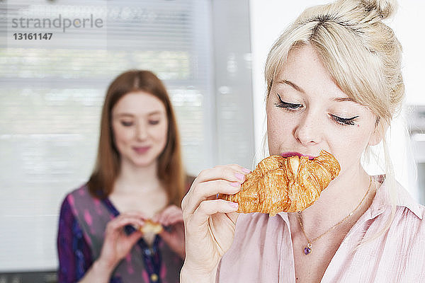 Junge Frauen essen Croissants