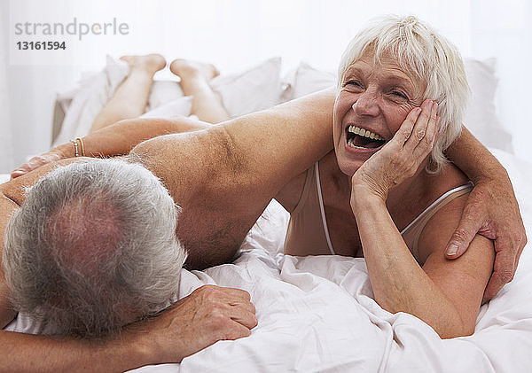 Älteres Ehepaar lacht im Bett