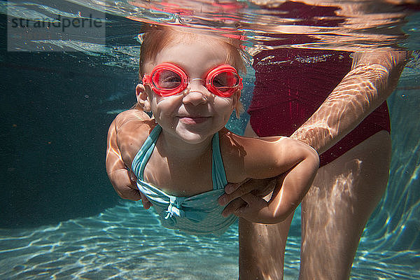 Unterwasserporträt eines Mädchens  das schwimmen lernt