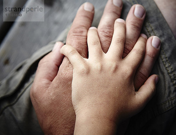 Nahaufnahme der sich berührenden Hände von Vater und Söhnen