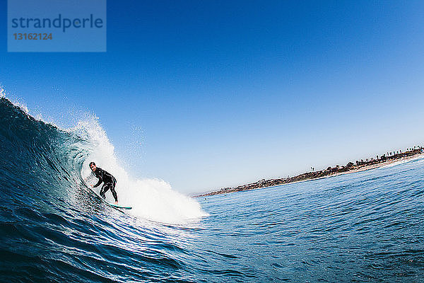 Mittelgroßer erwachsener männlicher Surfer beim Surfen auf gekrümmten Wellen  Carlsbad  Kalifornien  USA
