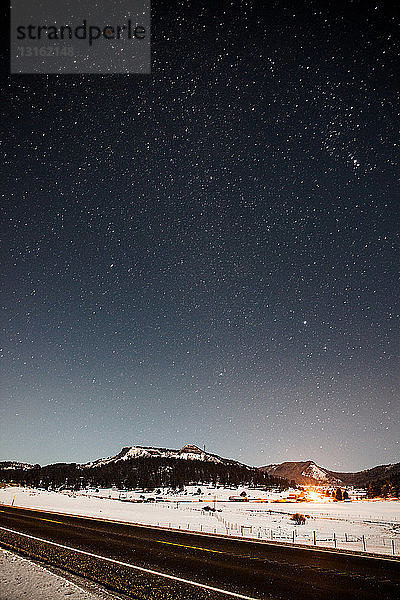 Blick auf den Highway und die schneebedeckten Berge bei Nacht  Pagosa Springs  Colorado  USA