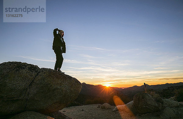 Junger Mann schaut bei Sonnenuntergang auf die Landschaft hinaus  Los Angeles  Kalifornien  USA