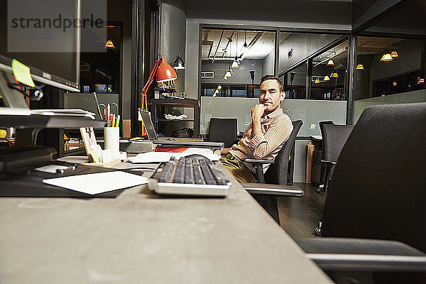 Porträt eines am Schreibtisch sitzenden Geschäftsmannes im Büro